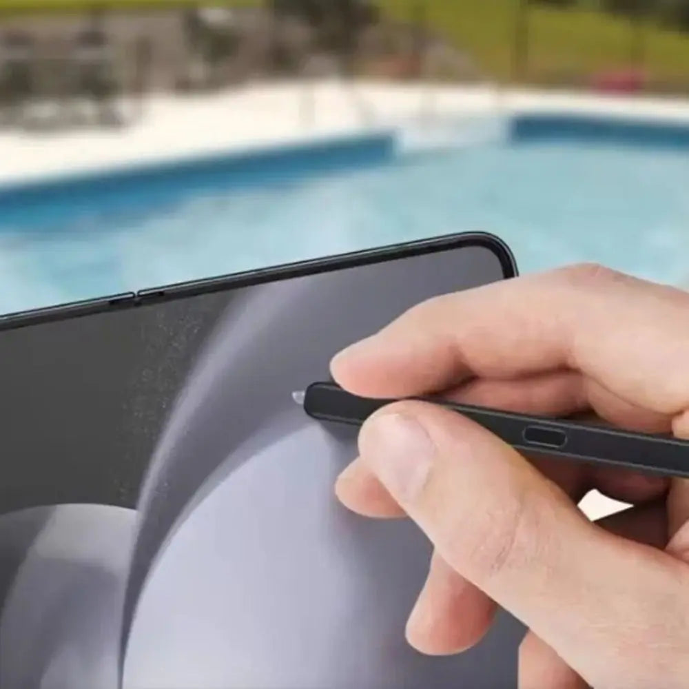 Hand holding slim black stylus on Samsung Z Fold3 display near hinge by pool best stylus for Samsung Z Fold3 precision tip